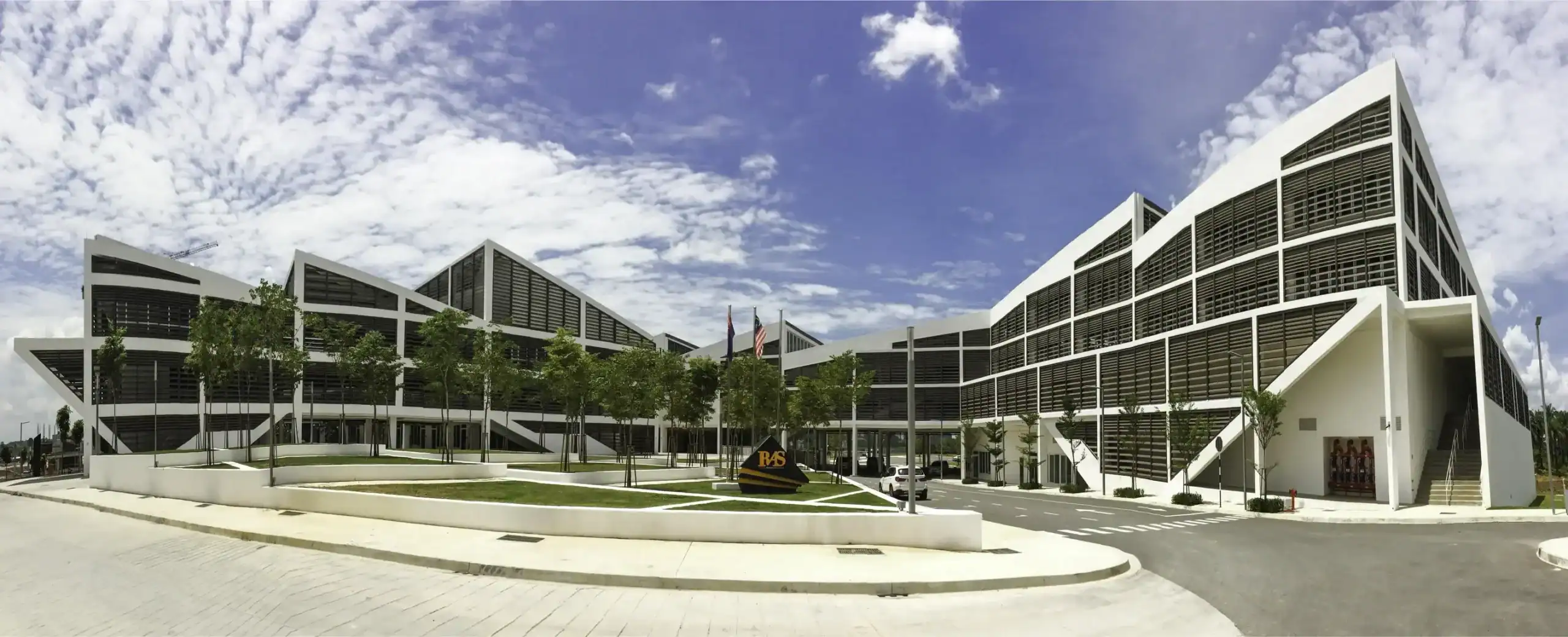 Modern school building with glass facade and landscaped surroundings.