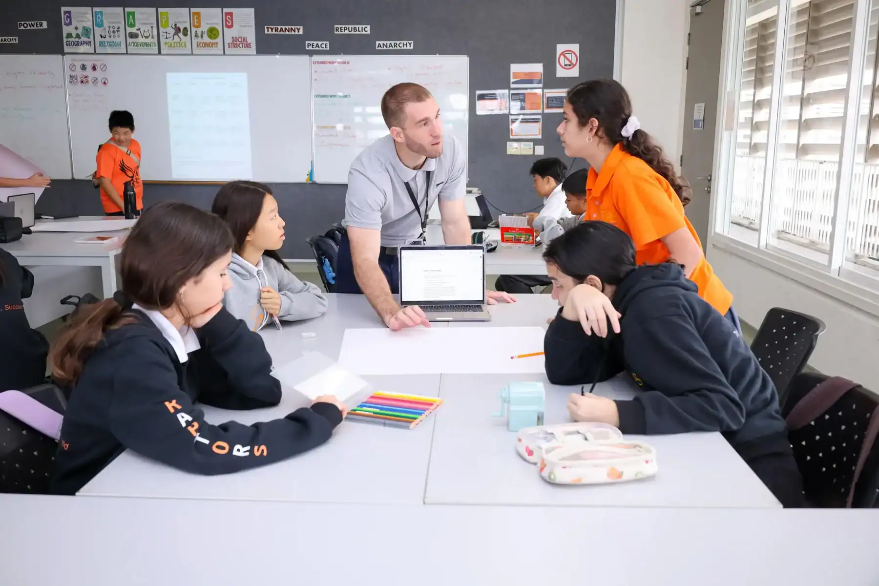 Students and teacher engaged in classroom discussion at Raffles American School.