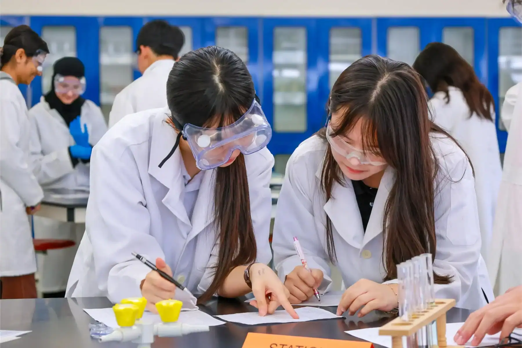 Students conducting science experiments in a classroom at Raffles American School.