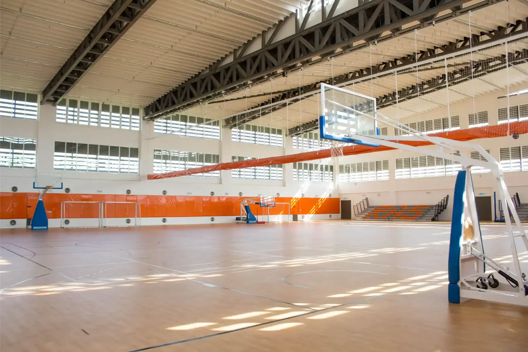 Indoor basketball court at Raffles American School with high ceilings and natural light.