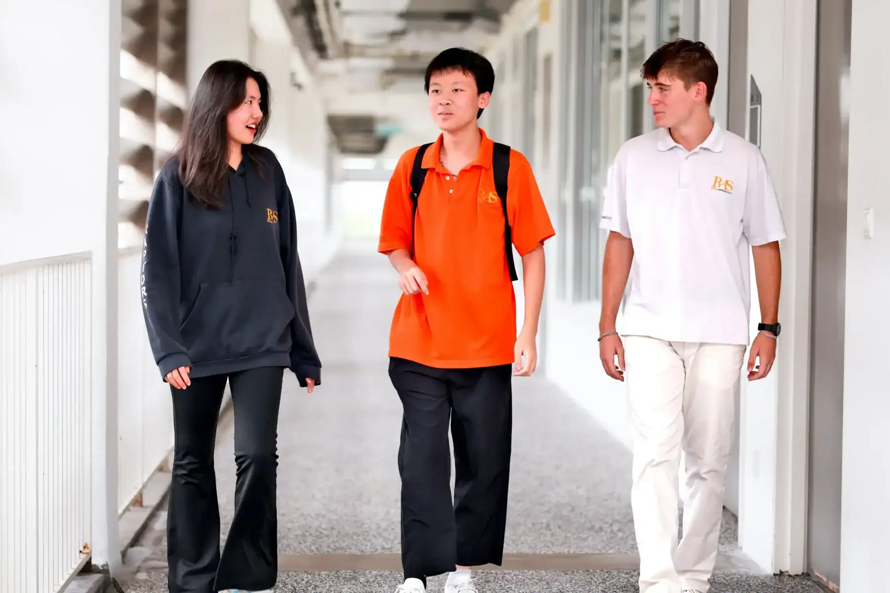 Students walking in school corridor at Raffles American School.