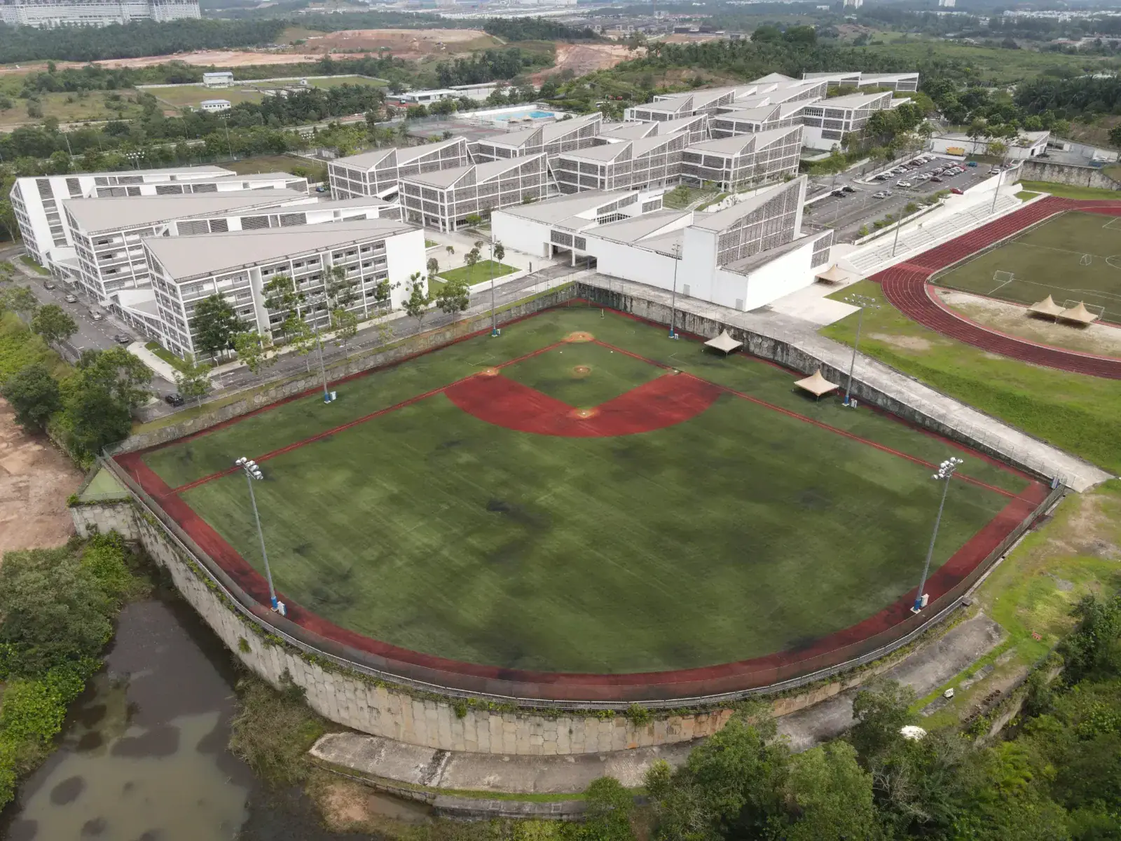Aerial view of Raffles American School with sports fields and modern buildings.