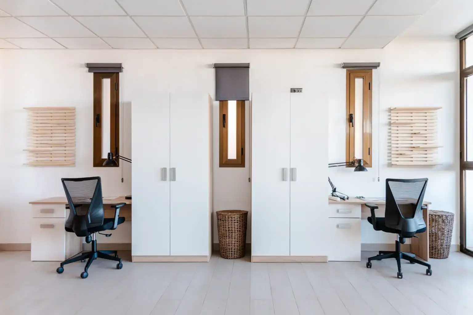 Modern school study area with white desks, ergonomic chairs, and wooden accents for optimal learning environment.