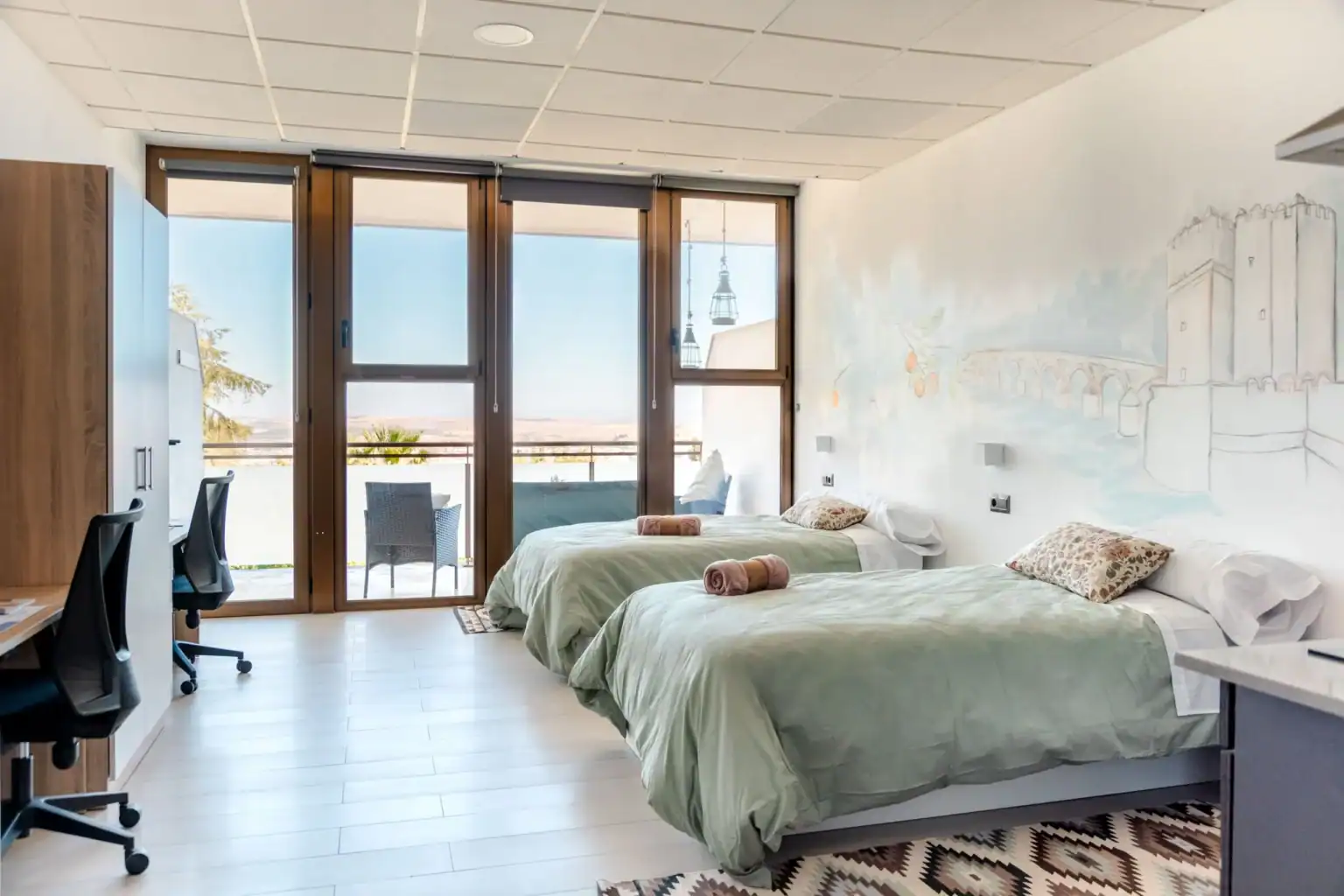 Modern student dorm room with two beds and balcony view at a world school.