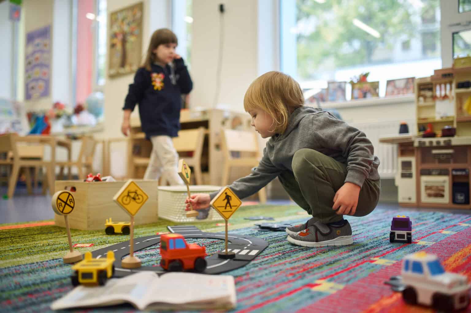 Children playing educational traffic safety game in classroom for early childhood learning.