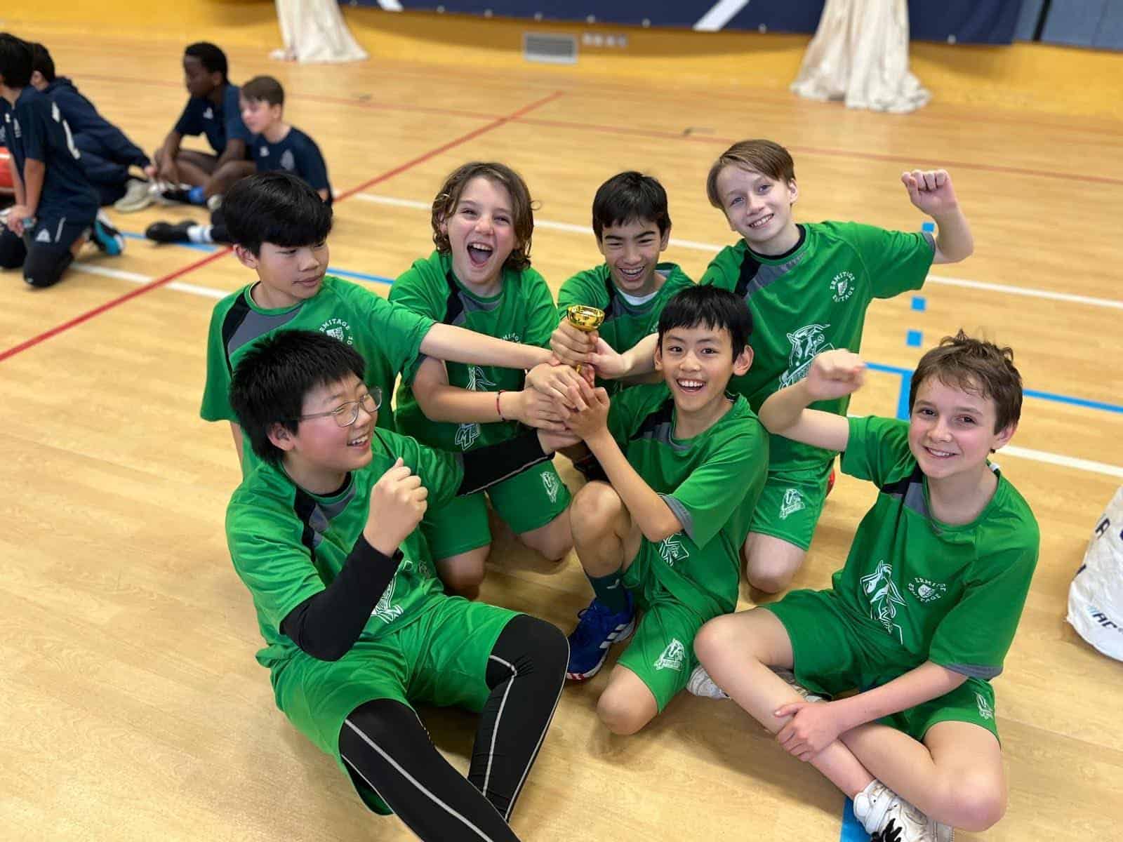 Young athletes celebrating victory in indoor sports event.