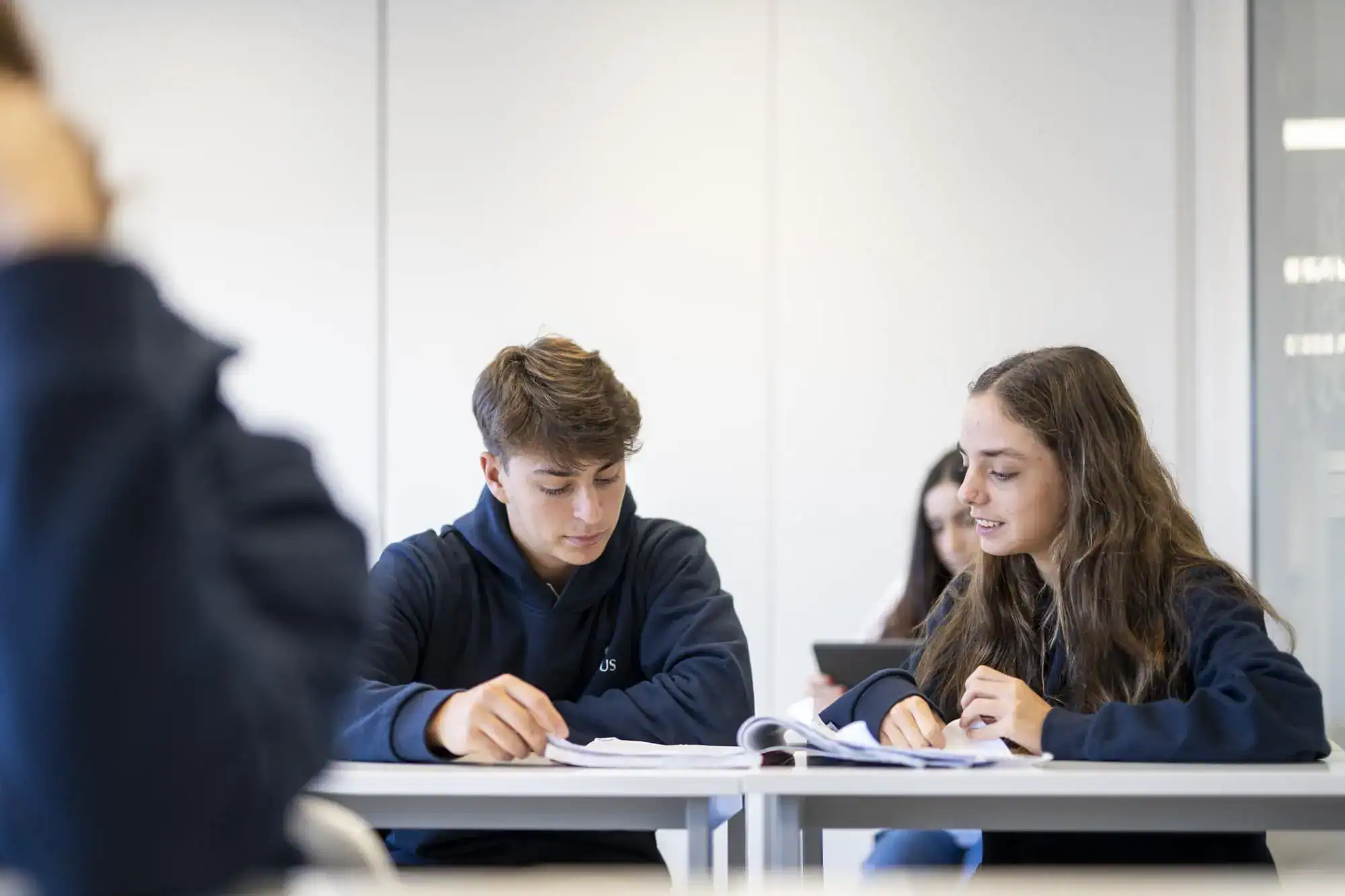 Skoncentrowani uczniowie uczą się razem w nowoczesnej klasie szkoły międzynarodowej.