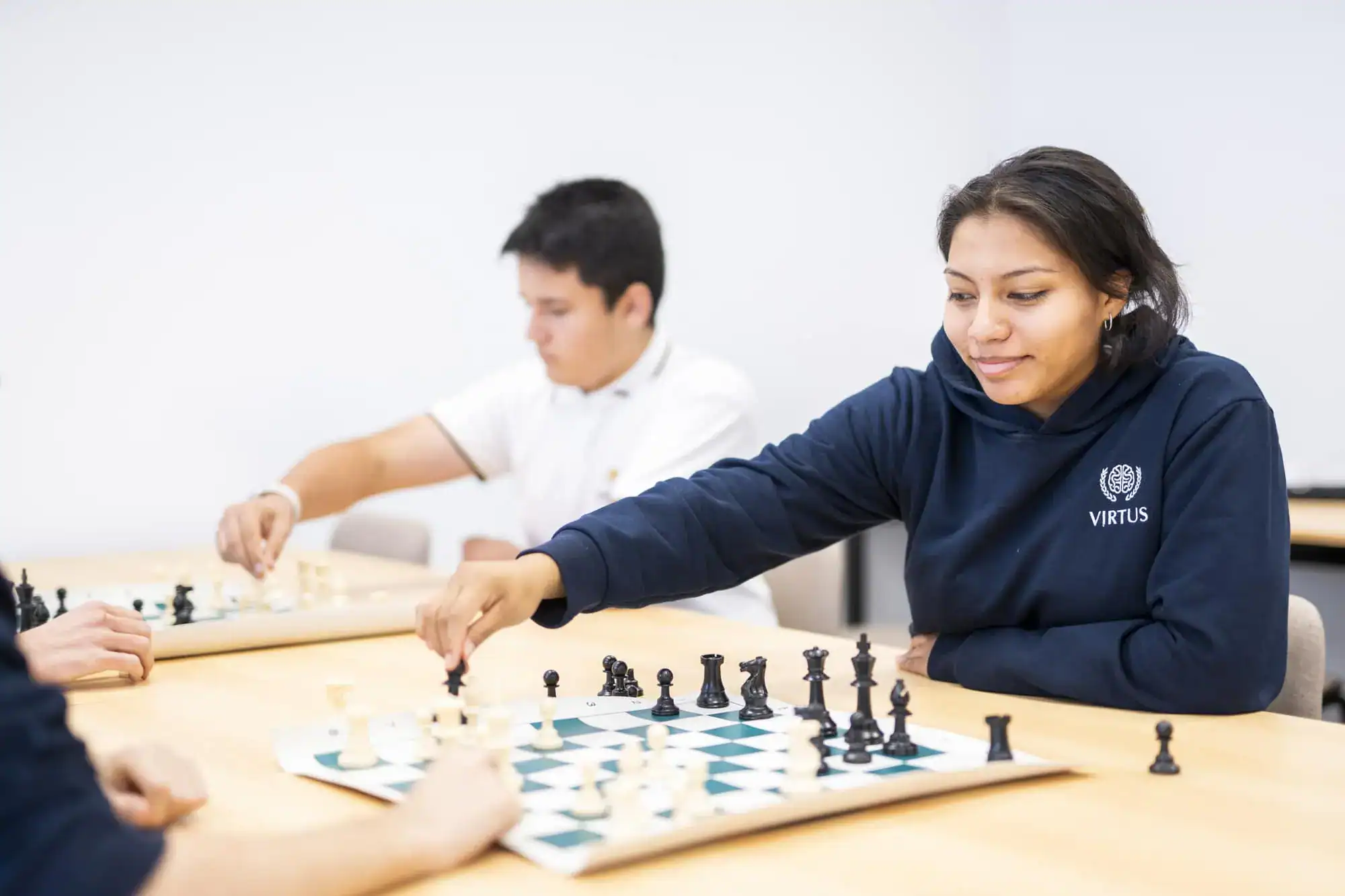 Inteligentni uczniowie grający w szachy, podkreślający światową doskonałość szkół i osiągnięcia akademickie.