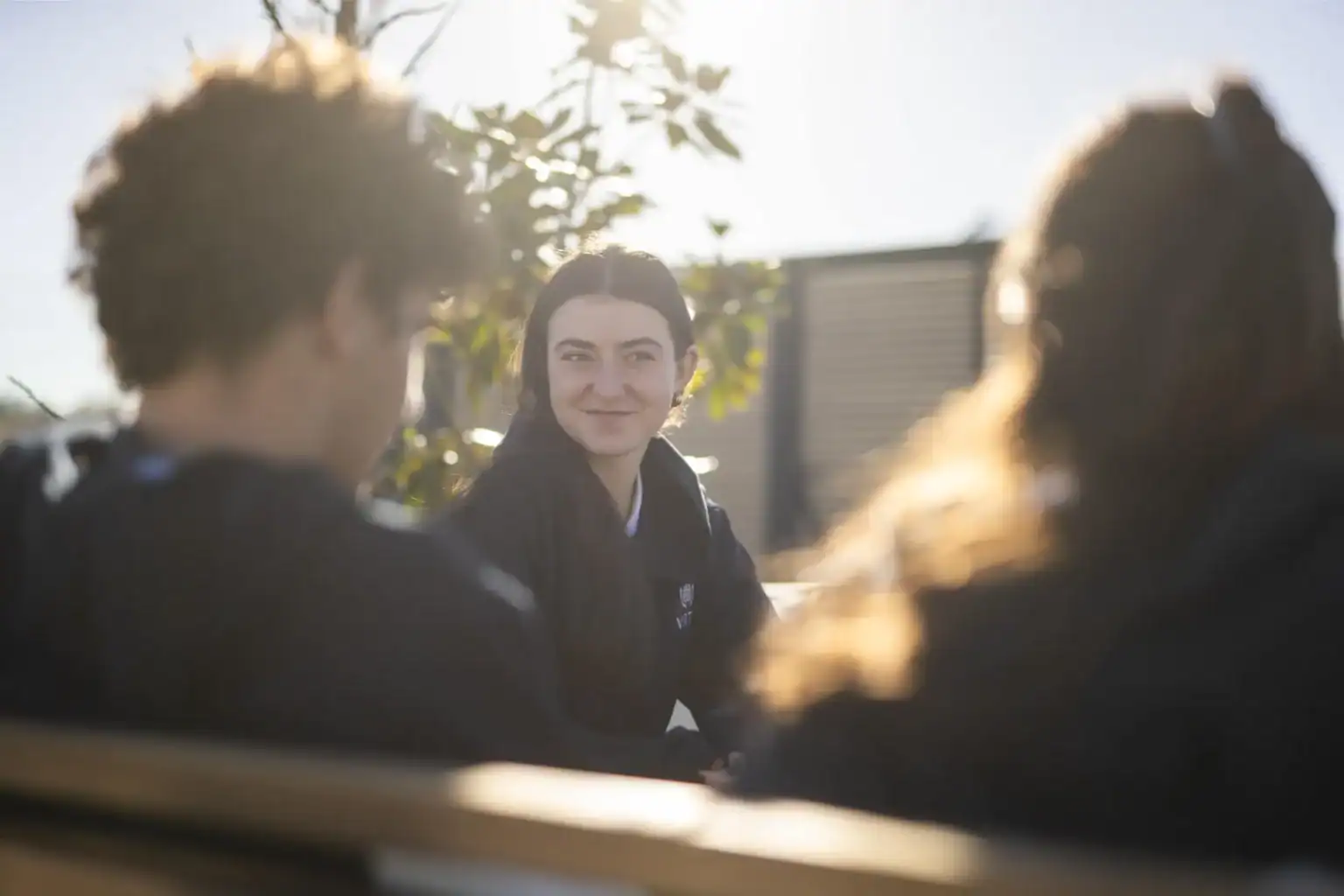 Młodzi uczniowie w słonecznej szkole na świeżym powietrzu w World Schools, wspierającej globalną edukację i zaangażowanie uczniów.