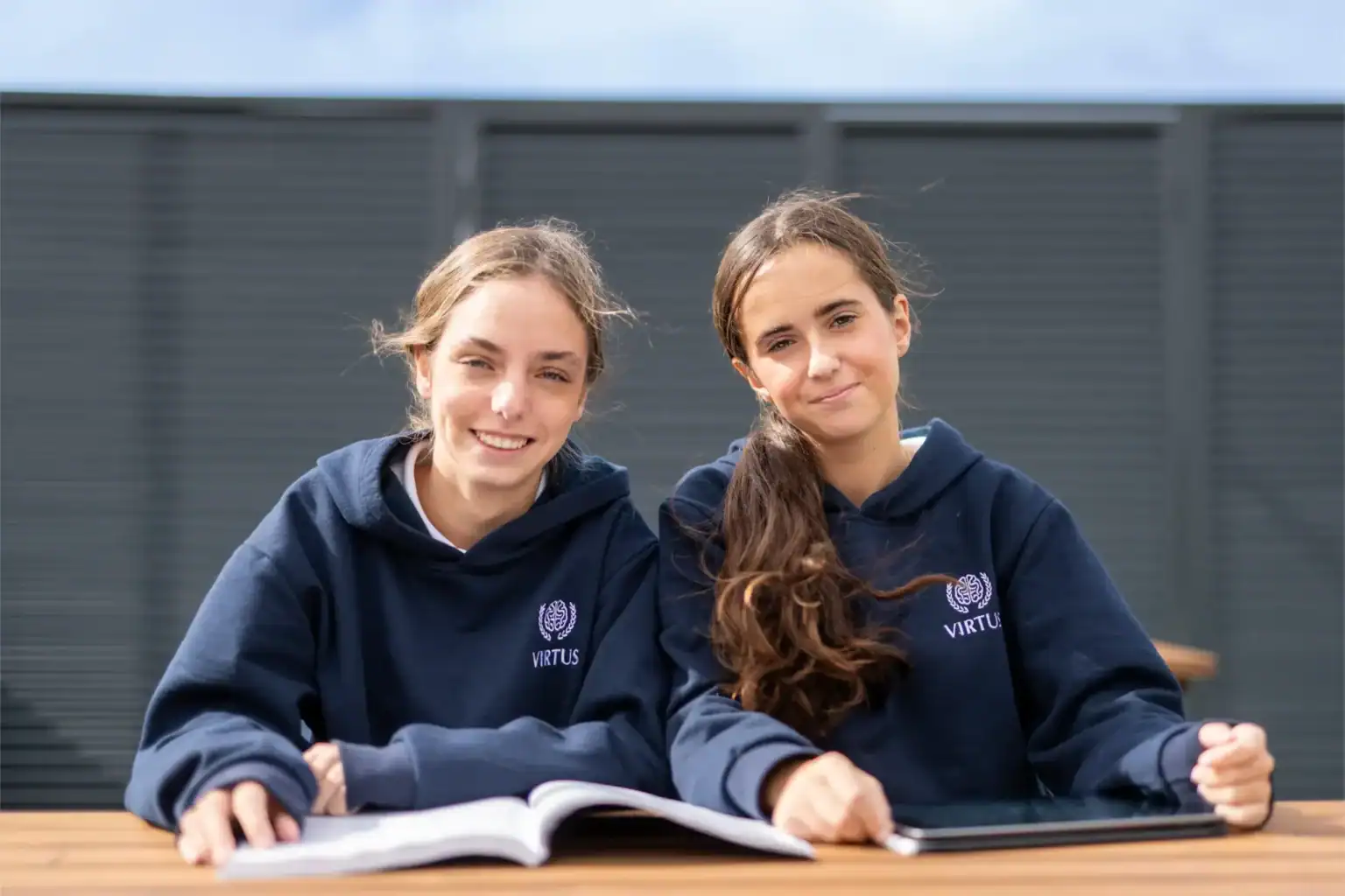 Uczniowie uczący się na świeżym powietrzu w mundurkach szkolnych w najlepszej międzynarodowej szkole, promującej doskonałość akademicką i różnorodne możliwości edukacyjne.