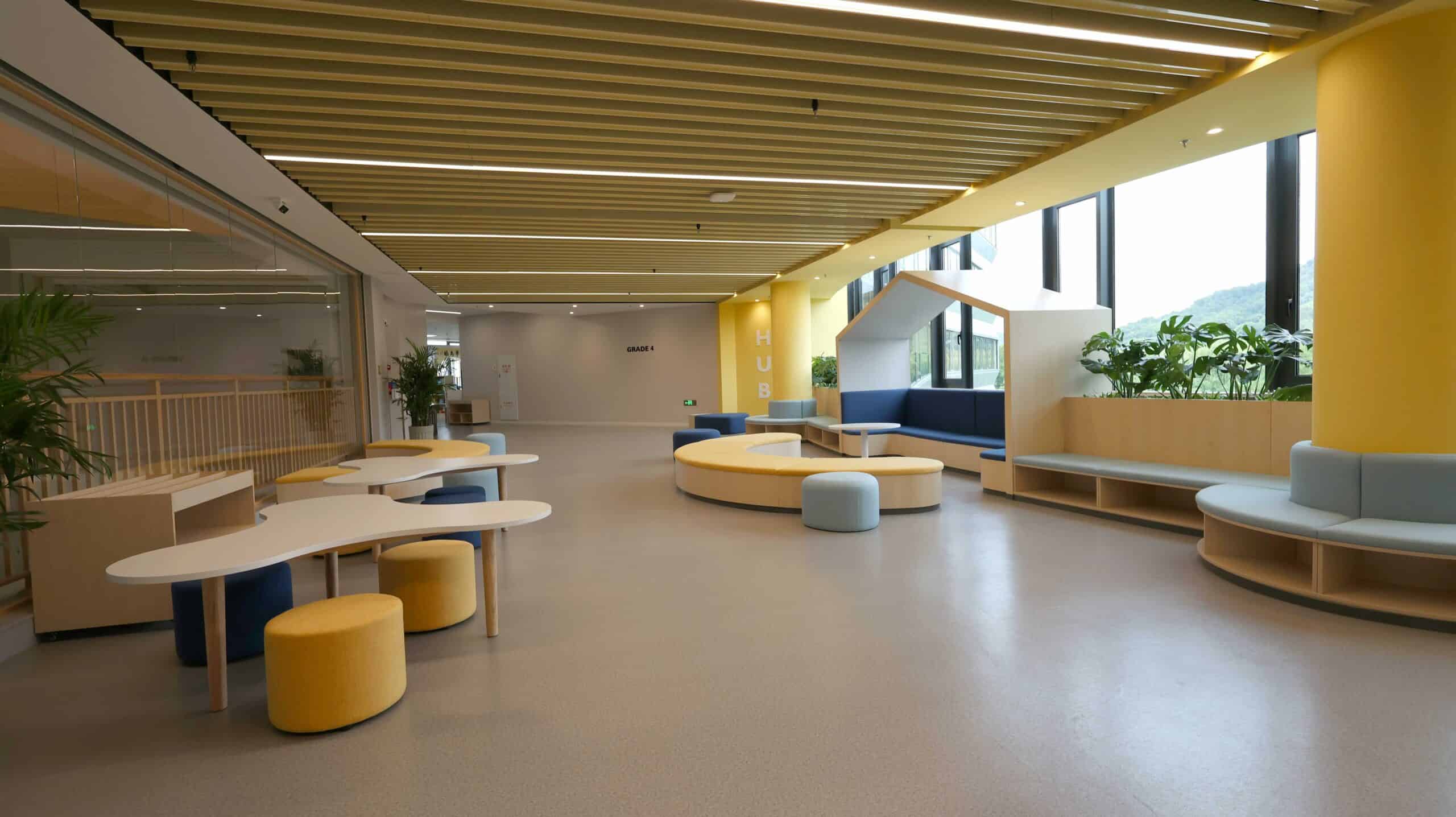 Bright modern school lobby with colorful seating and large windows, showcasing a welcoming learning environment.