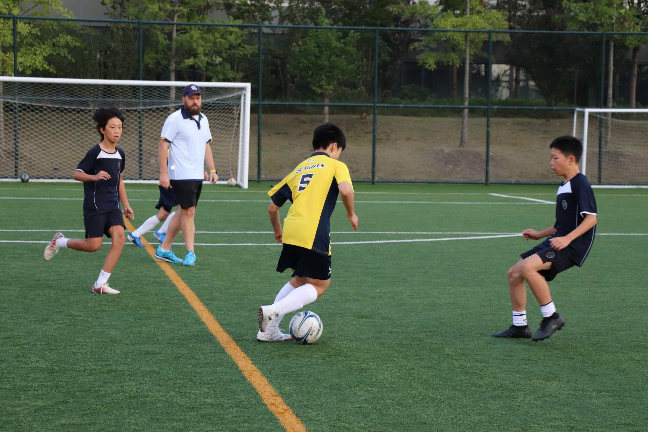 Young students playing soccer on a school field, promoting sports and physical education at World Schools.