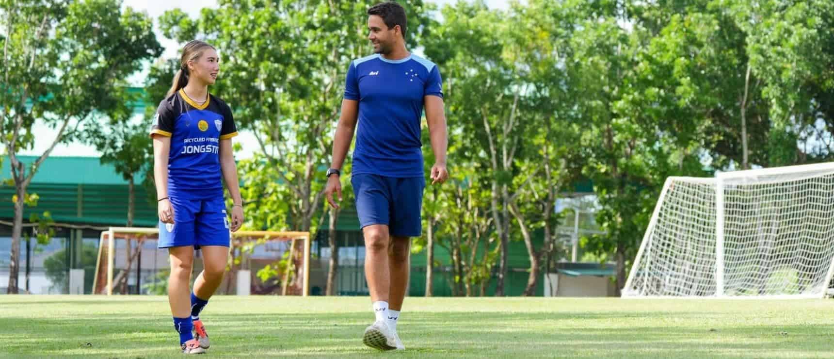 Youth soccer players practicing on a field with coach in a park setting.