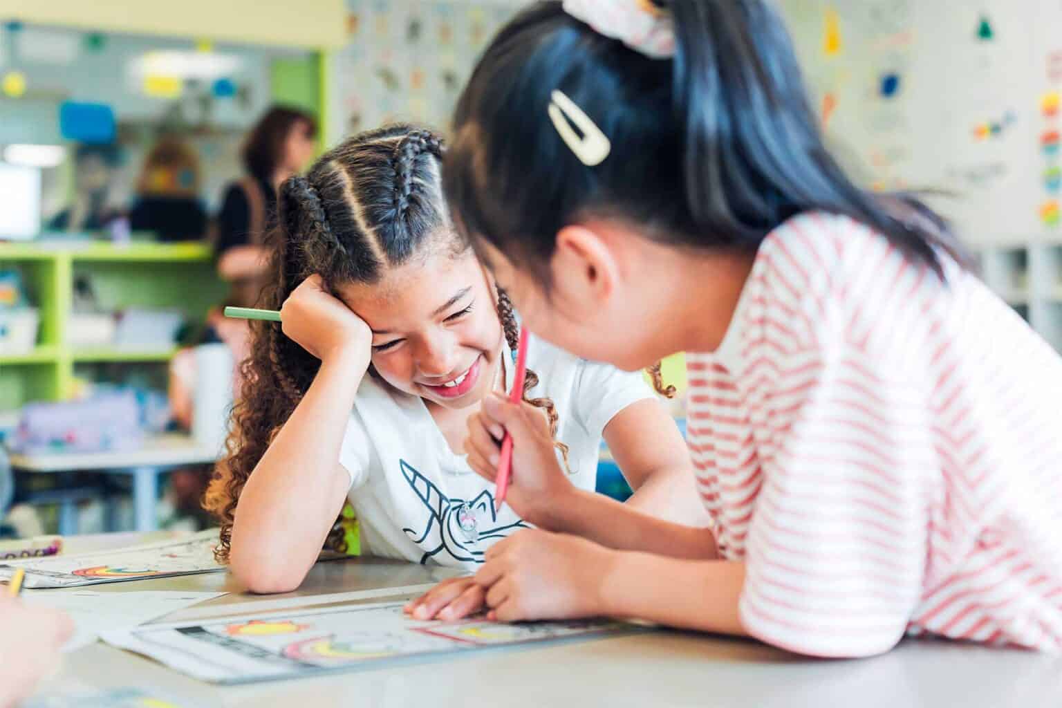 Smiling children engaging in classroom activity at World Schools, fostering creativity and learning.