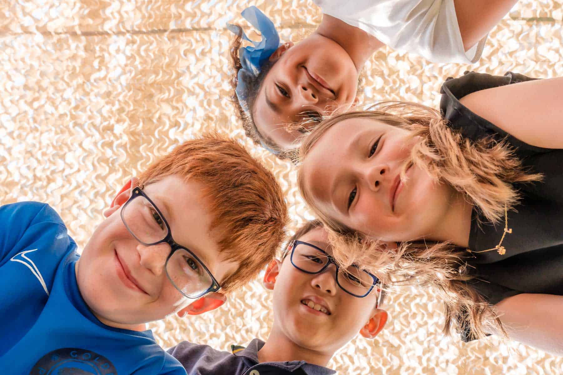 Smiling children from diverse backgrounds enjoy learning at a world school.