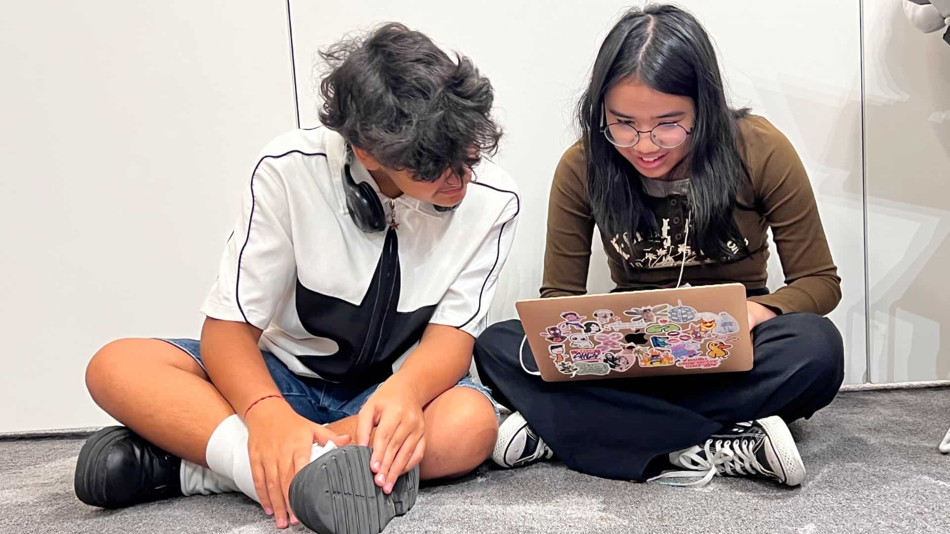 Young students collaborating on a laptop, studying, promoting international education and global learning.