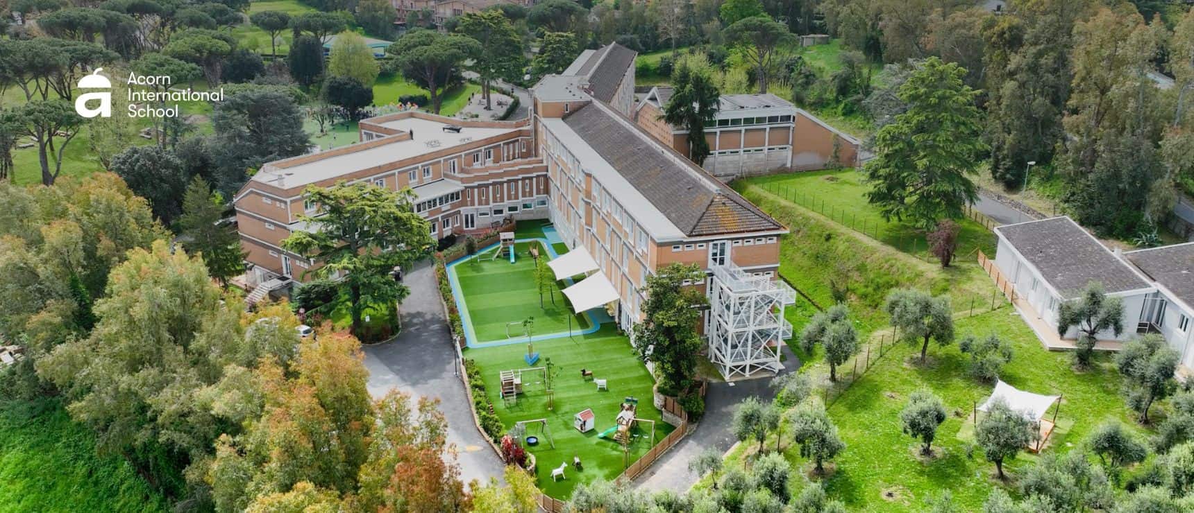 Bright aerial view of Acorn International School campus highlighting modern architecture and lush green outdoor areas.