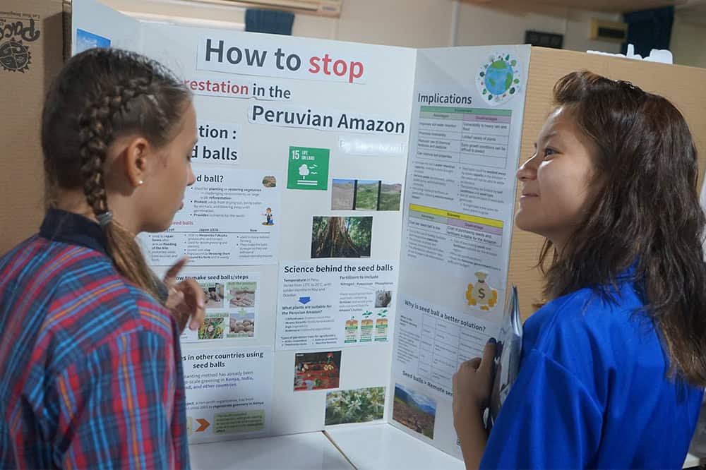 학교 과학 박람회에서 환경 보존에 관한 과학 프로젝트를 발표하는 어린이들.