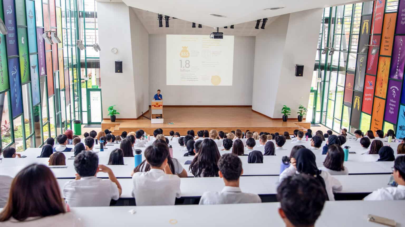 Aerial photo of diverse students attending a lecture in a modern classroom at a prestigious global school.