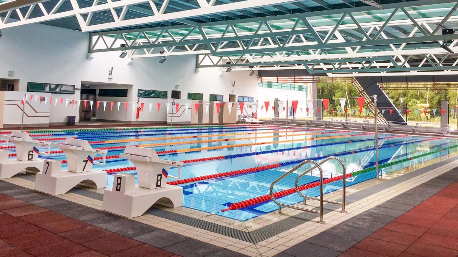 Indoor swimming pool at a modern school with lanes and starting blocks.