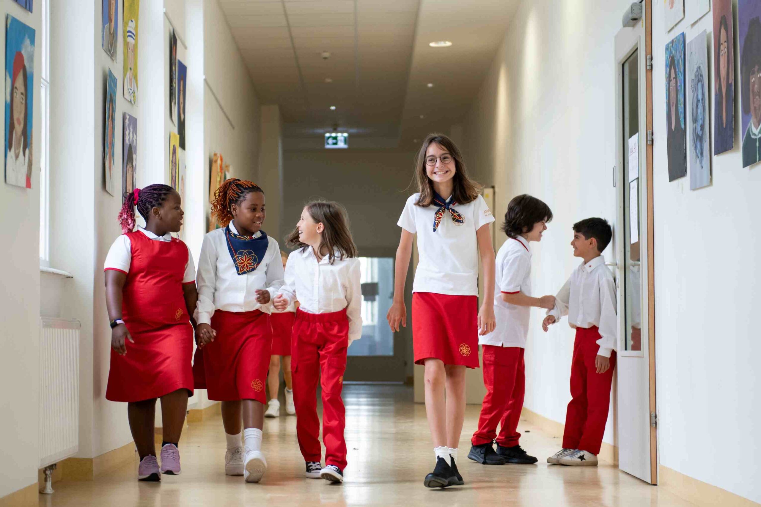 The “Happy School” Philosophy: How AMADEUS Vienna Supports Students Wellbeing 3 Students walking in school corridor, engaging and smiling.