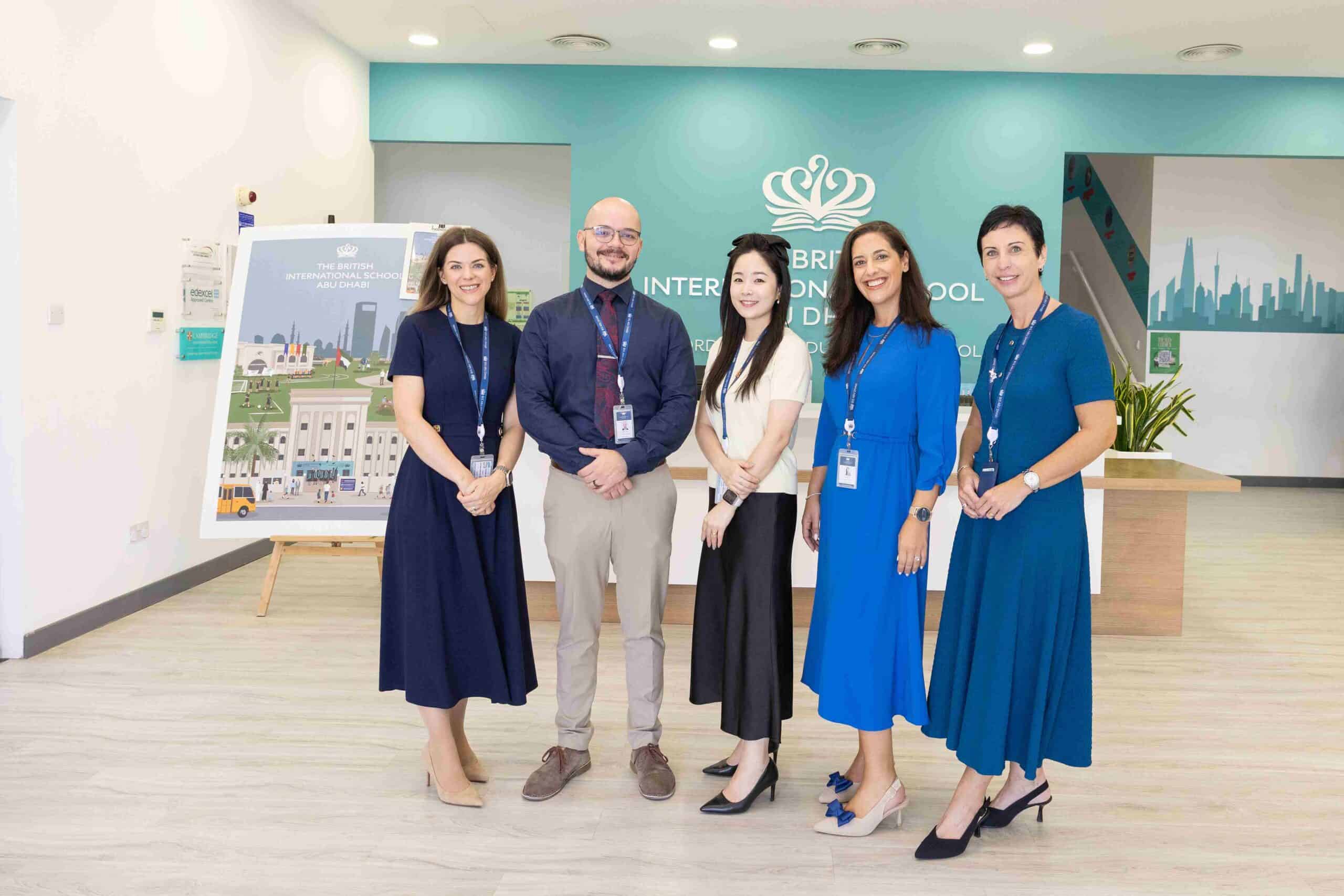 O que procurar numa escola internacional: Da candidatura ao primeiro dia 6 Diverse educators standing together in a school lobby, promoting international education excellence.