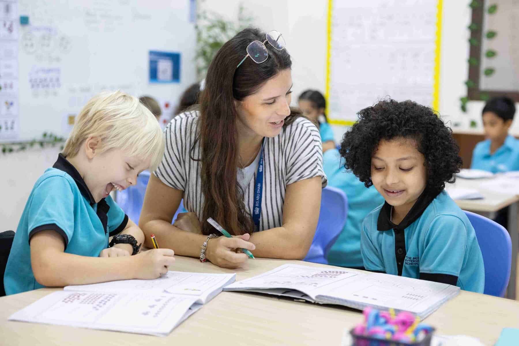 BIS Abu Dhabi Celebrates Renewed ADEK ‘Outstanding’ Rating and a Thriving School Community 5 Teacher engaging with young students in a classroom setting at a world school.