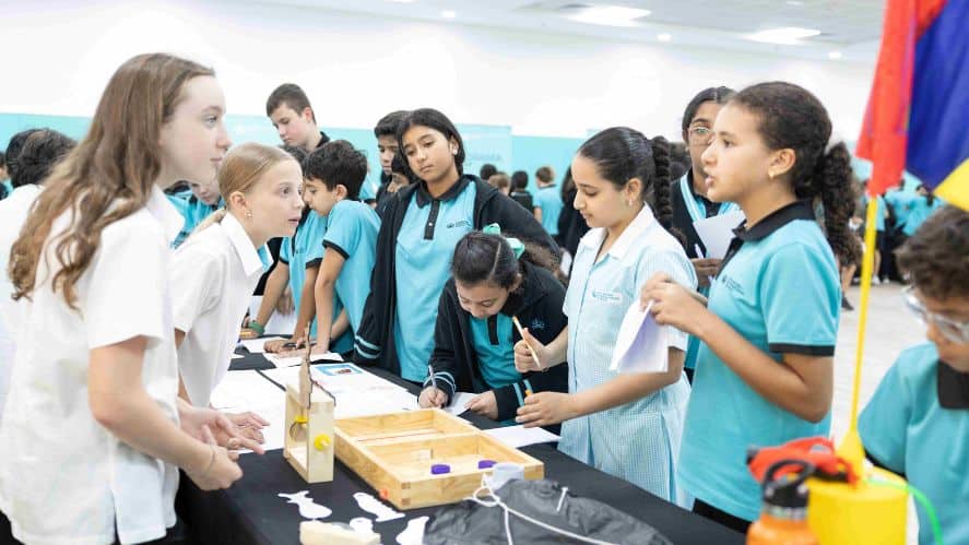 Students participating in a science fair at a world school event.