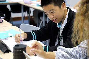 Young students collaborating and learning in a classroom setting at a world school.
