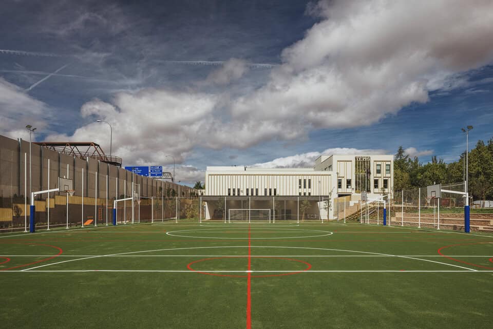 Modern school sports field with basketball courts and fitness areas at World Schools campus.