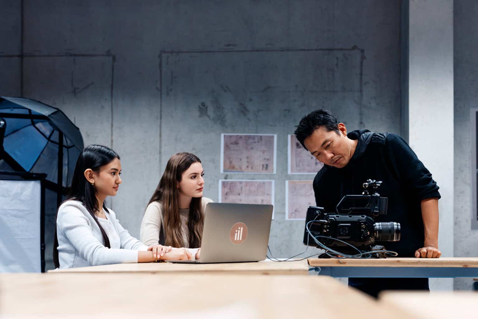 Young women working on a video production with a professional camera in modern classroom or studio setting.