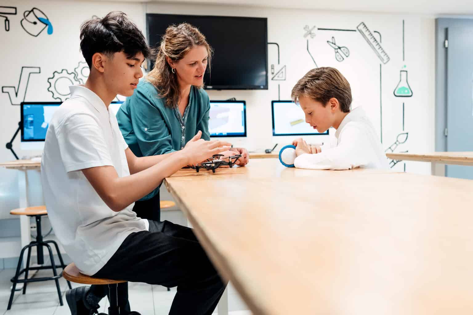 Innovative classroom with students exploring robotics and technology, guided by a teacher in a modern educational environment.
