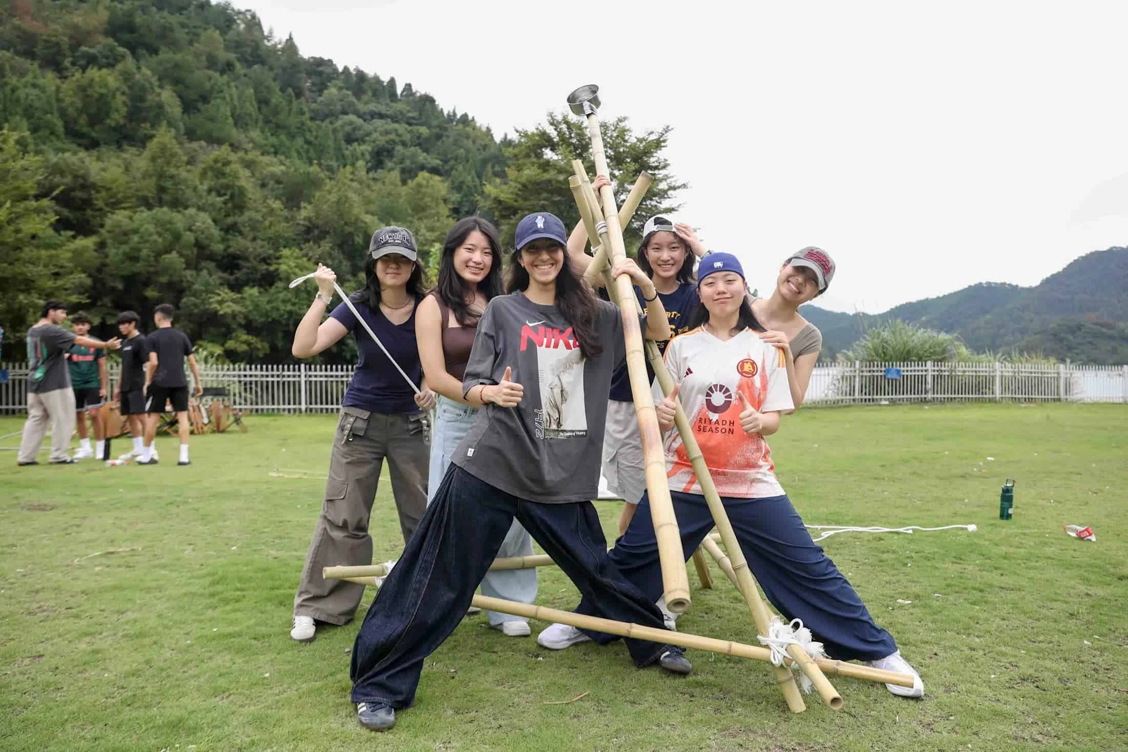 Students participating in outdoor team-building activities at a scenic school campus.