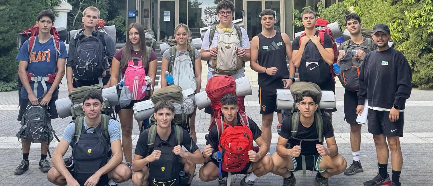 Backpacker students outside World Schools campus, excited for outdoor educational adventure.