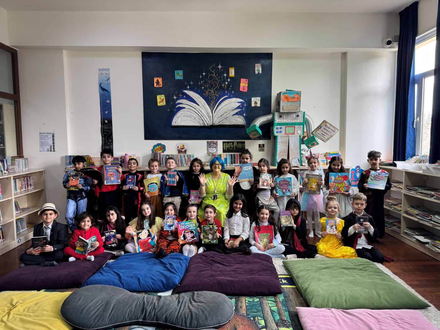 Group of diverse children in a classroom holding books and smiling.