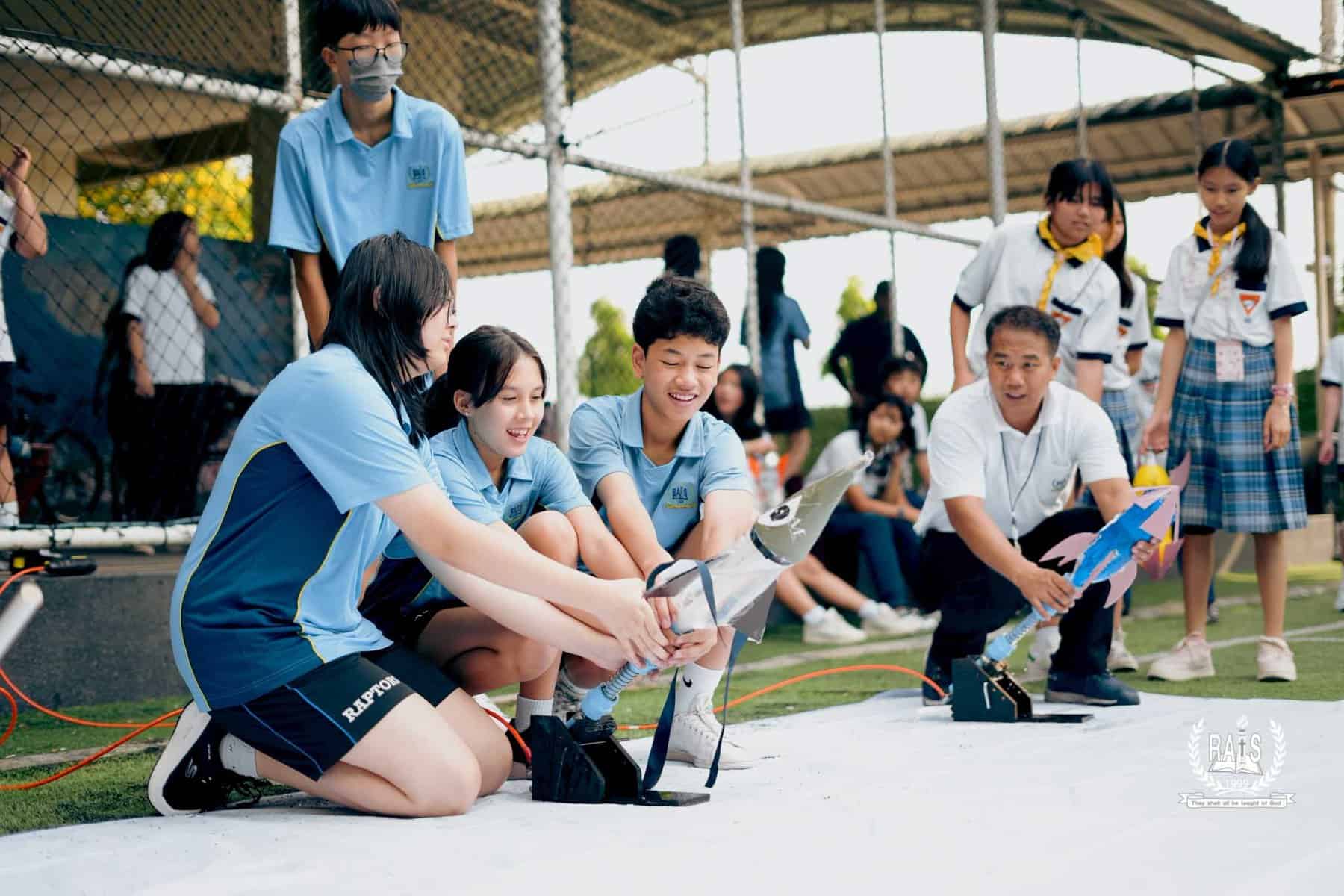 STEM 3 Students working on a robotics project during a school event, engaging in STEM activities outdoors.