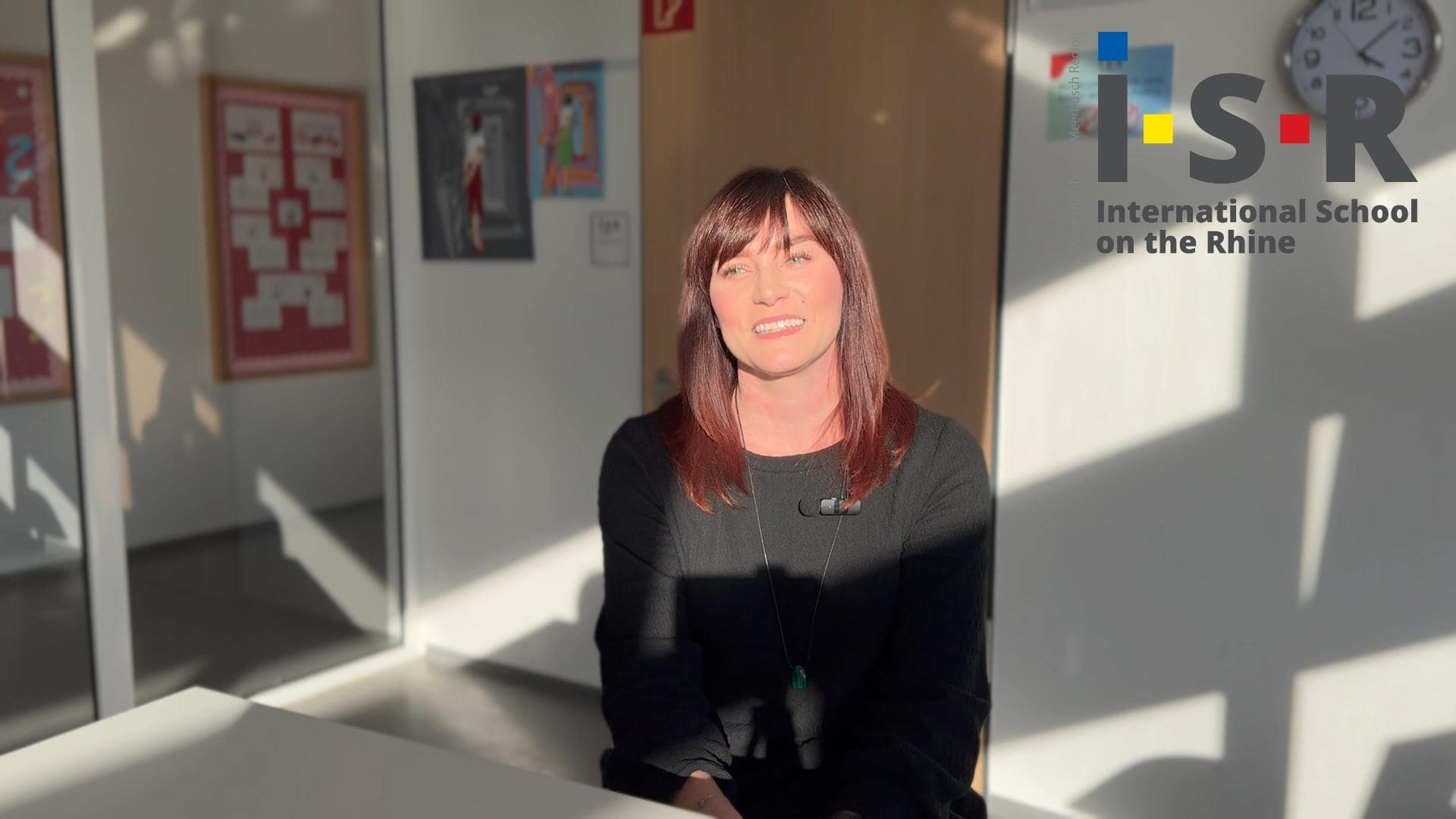 Bright woman smiling at International School on the Rhine, showcasing a warm educational environment.