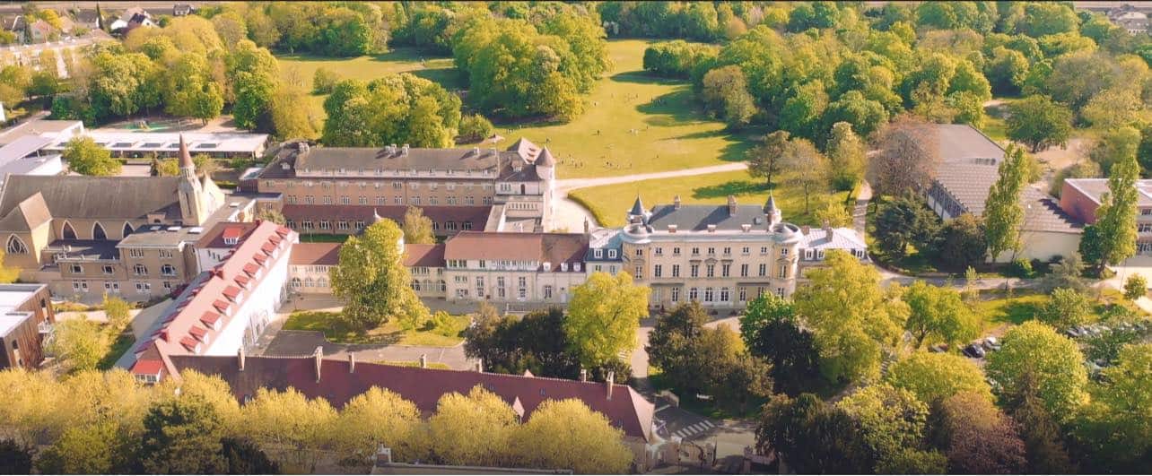 Bright aerial view of prestigious world schools surrounded by lush greenery and historic architecture.