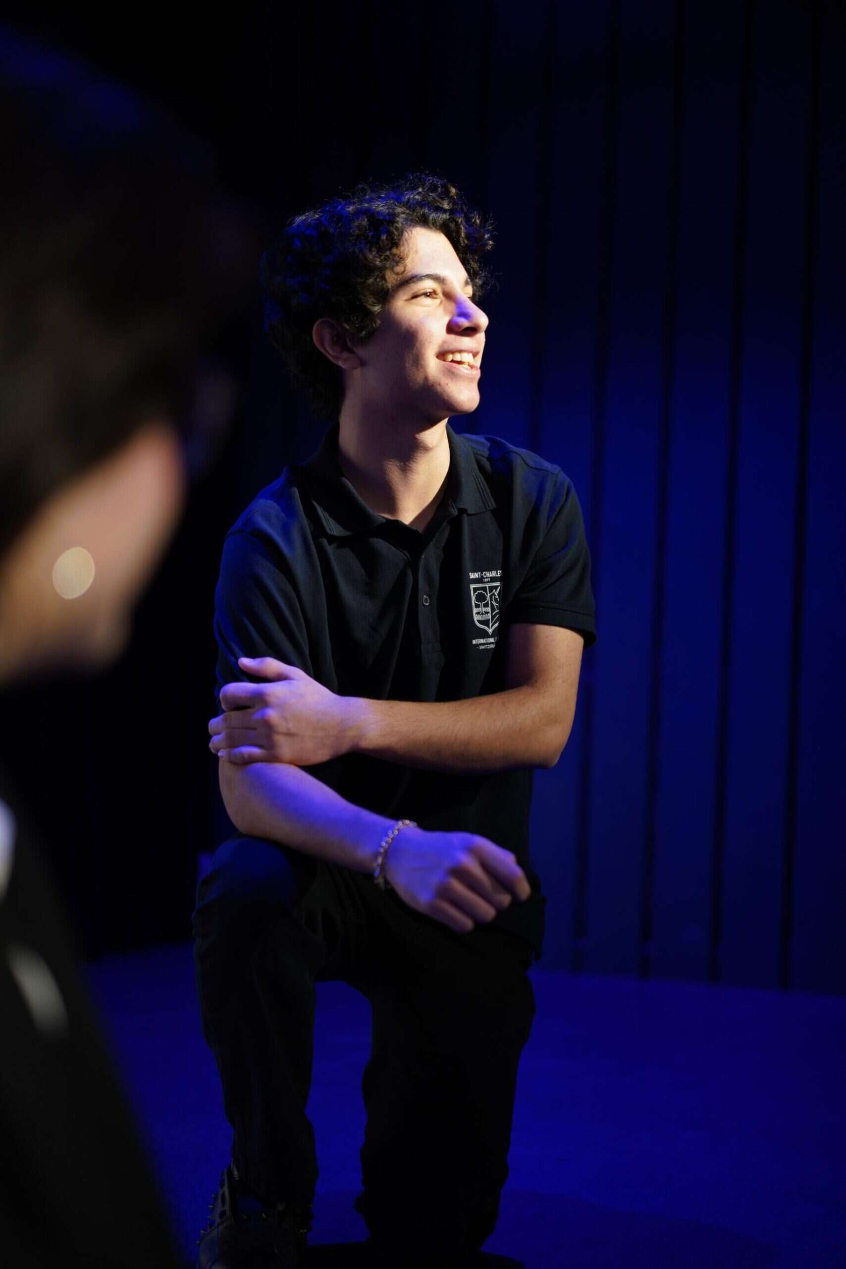 Bright young student with curly hair smiling at an educational event at World Schools.
