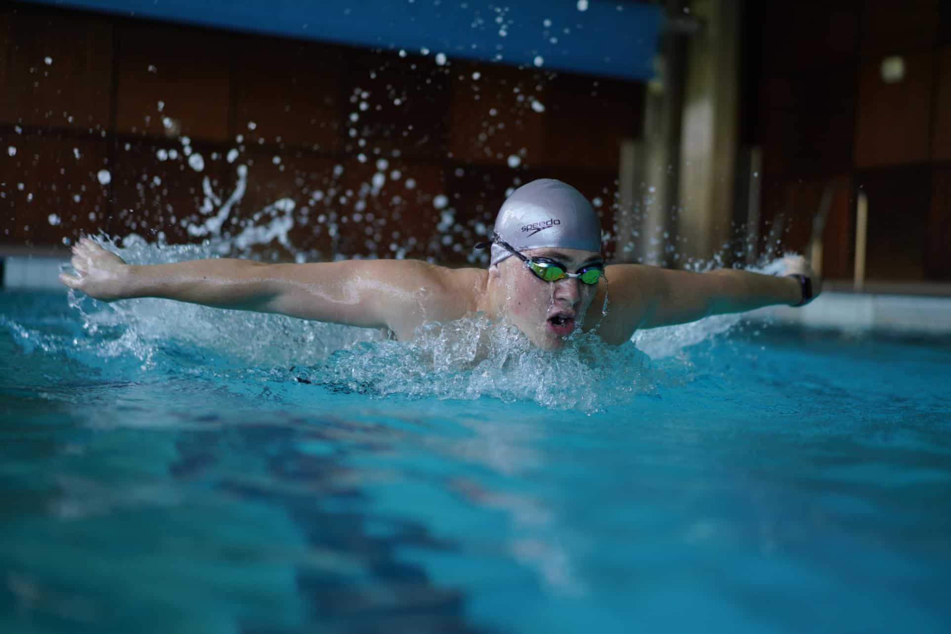 Child swimming competitively in pool, showcasing athleticism and focus for World Schools programs.
