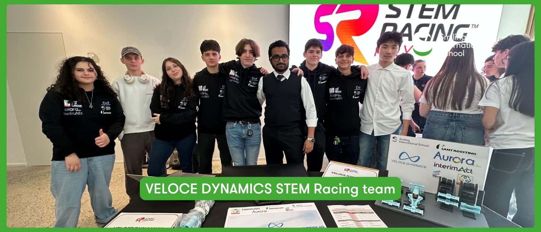 Veloce Dynamics STEM Racing team with students and coach at an event.