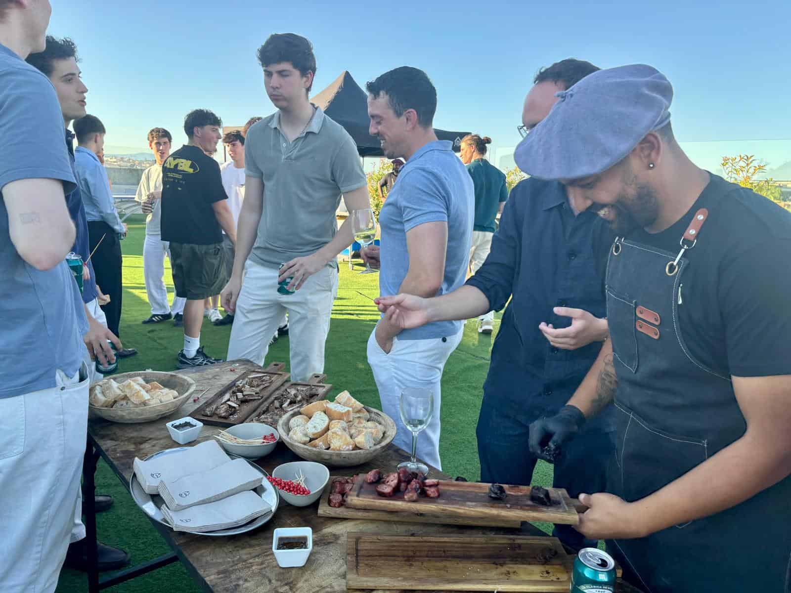 Students and chef at outdoor food event on a sunny day.